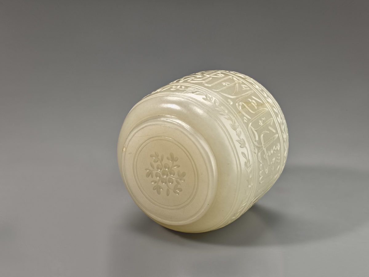View of a white jade cup showing a decorative detail on the bottom.