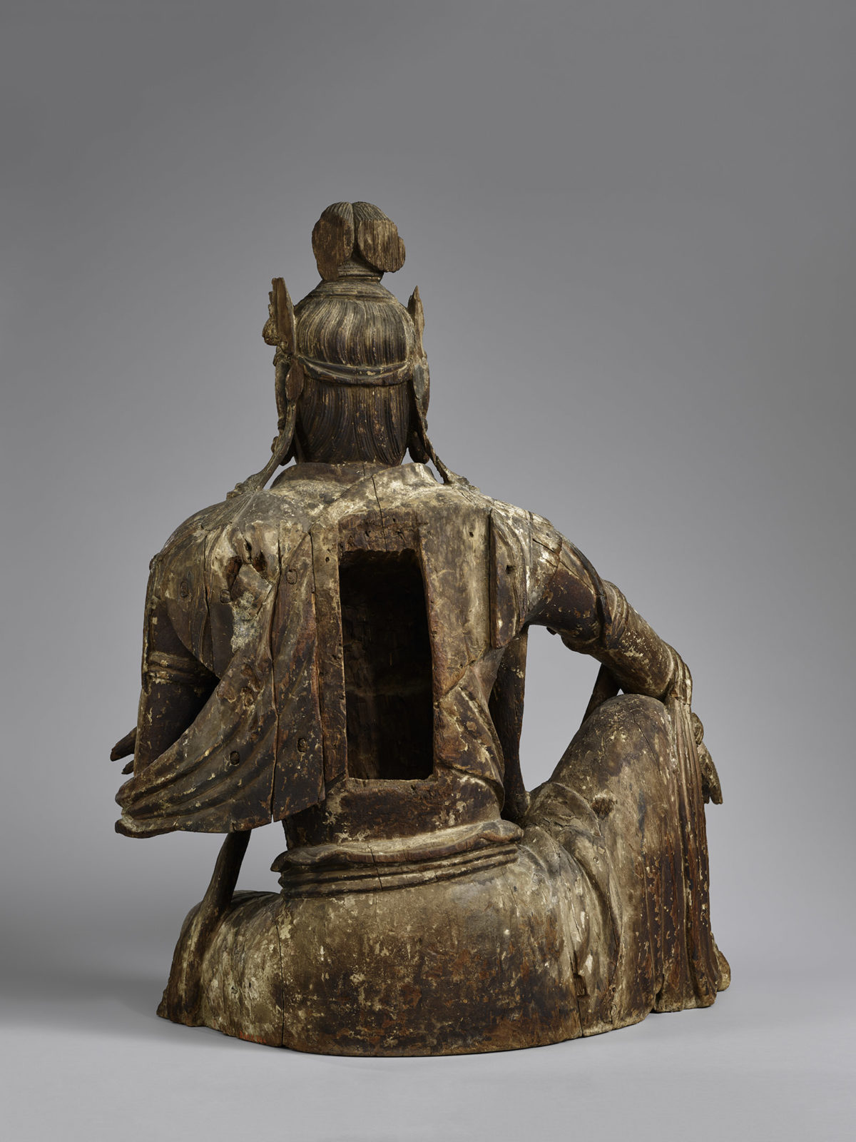 Rear view of a wooden statue of Guanyin, showing a hollow space in the back.