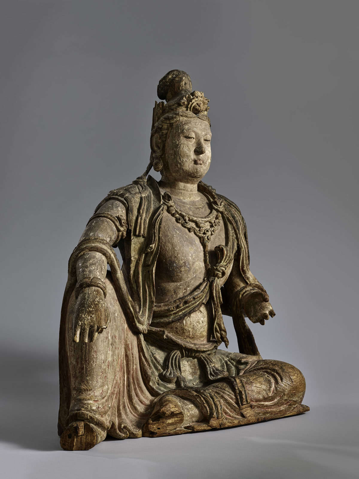 Partial profile view of a wooden statue of Guanyin.