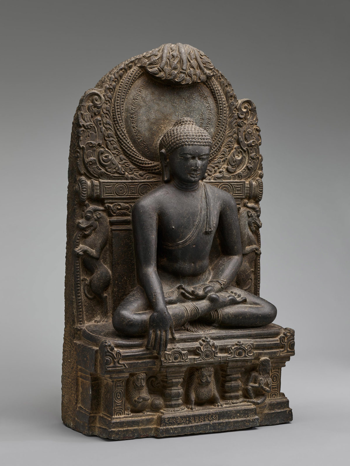 Side view of a carved figure of a seated Buddha.